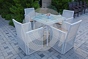 Chairs and tables of a restaurant seating outside with parasols.Garden terrace white table set up for a lovely brunch . White