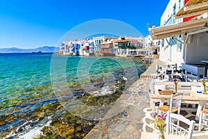 Chairs with tables in typical Greek tavern in Little Venice part of Mykonos town, Mykonos island, Greece