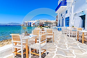 Chairs with tables in typical Greek tavern in Little Venice part of Mykonos town, Mykonos island, Greece