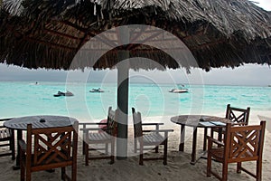 Chairs and tables under big umbrella at beach