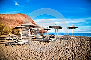 Chaise-longues and sun umbrellas in Playa de la Tejita photo