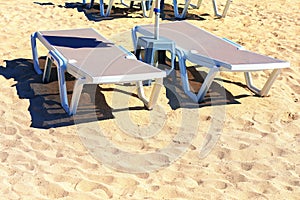 chaise lounges at sandy beach