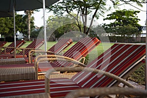 Chaise lounges with soft red mattresses stand in a row. The recreation area. The concept of leisure and travel. Without