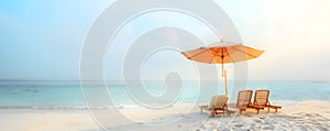 Chaise lounges and sun umbrella on tropical beach. Panoramic view of empty chaise lounges under umbrella on ocean shore