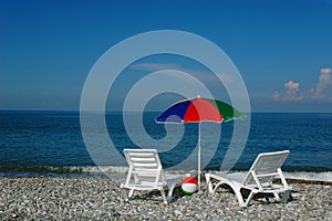 Chaise lounges and umbrella on a sea coast