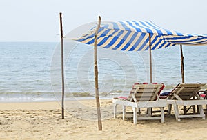 Chaise lounges under a canopy on the beach near the ocean