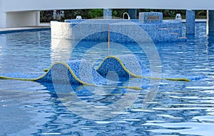 Chaise lounges in water. Swimming pool outdoors in Mexico.