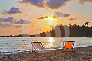 Chaises longues on the beach at sunset