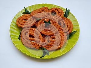 Chakli in a Green Plate isolated on White Background. Indian Snack Chakli or chakali made from deep frying portions of a lentil