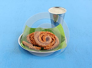 Chakli Indian Savory Snack on a Banana Leaf on a Plate and Coffee