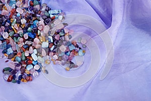 Chakra healing crystals on pastel silk background