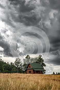 Chalet in country stormy clouds on the dark sky