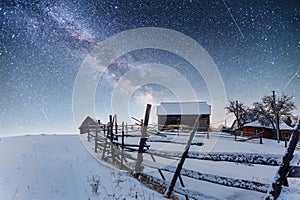 Chalets in the mountains at night under the stars.