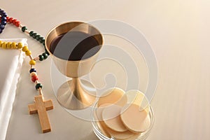 Chalice and consecrated host on table with cross elevated view photo