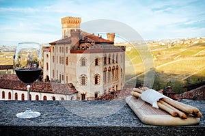 Chalice of wine with breadsticks and the castle of Barolo Italy