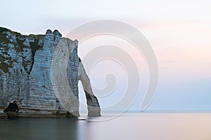 Chalk cliffs of Etretat with the natural arch Porte d`Aval