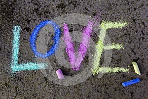 Chalk drawing on asphalt: Colorful word LOVE