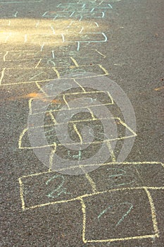 Chalk drawings on asphalt. Hopscotch game concept. Childhood concept. Painted numbers on the road. Outdoor games