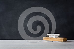 Chalk and eraser board on the white desk. Blackboard background