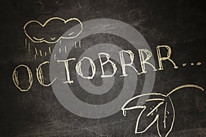 The chalk inscription OCTOBRRR, intentionally misspelling the word October, symbolizes the onset of cold weather in photo