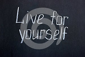 Chalk lettering on a blackboard Live for yourself photo