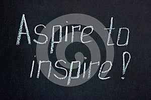 Chalk lettering on a dark board exclamation Aspire to inspire photo
