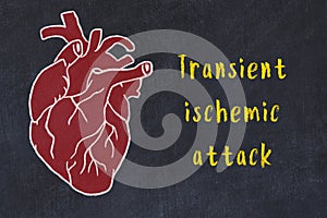 Chalk sketch of human heart on black desc and inscription Transient ischemic attack