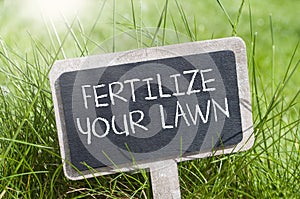 Chalkboard in the grass with fertilize your lawn photo