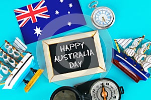 Chalkboard with the inscription: Happy day of Australia surrounded by shipwrights, a compass, a clock and an Australian flag on a