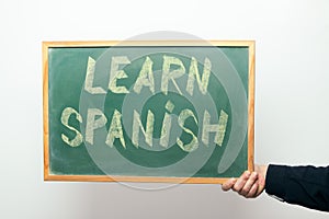 Chalkboard with LEARN SPANISH handwritten in chalk