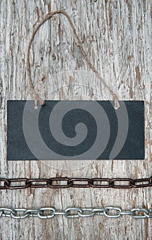 Chalkboard with metal chain on the old wood