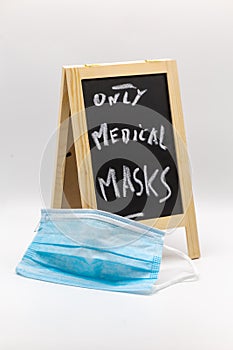 Chalkboard with note only medicals masks as warning with medical mask in the foreground at Covid-19 times photo
