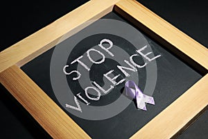 Chalkboard with purple ribbon and phrase STOP VIOLENCE on background