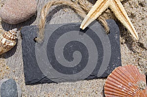 Chalkboard slate board on wood with sand, shells and star fish