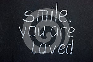 Chalkboard text `smile you are loved`