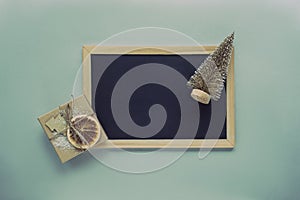 Chalkboard with a toy fir tree and gift in a box, top view, flat lay