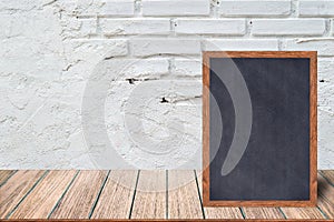 Chalkboard wood frame, blackboard sign menu on wooden table and with brick background.