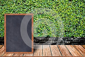 Chalkboard wood frame, blackboard sign menu on wooden table and grass wall background.