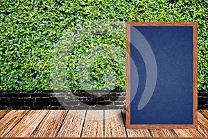 Chalkboard wood frame, blackboard sign menu on wooden table and grass wall background.