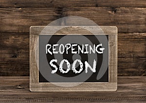 Chalkboard wooden background Reopening soon