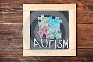 Chalkboard with word AUTISM and drawn puzzle pieces