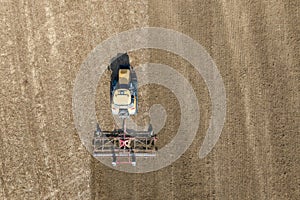 A Challenger MT 865 E tractor pulls the disc harrow through the field to prepare the soil