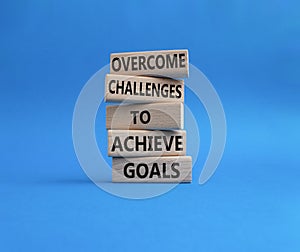 Challenges or goals symbol. Wooden blocks with words Overcome challenges to achieve goals. Beautiful blue background. Business