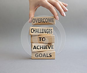 Challenges or goals symbol. Wooden blocks with words Overcome challenges to achieve goals. Beautiful grey background. Businessman