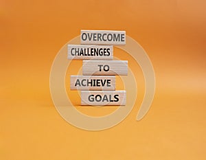 Challenges or goals symbol. Wooden blocks with words Overcome challenges to achieve goals. Beautiful orange background. Busine
