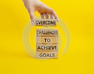 Challenges or goals symbol. Wooden blocks with words Overcome challenges to achieve goals. Beautiful yellow background.