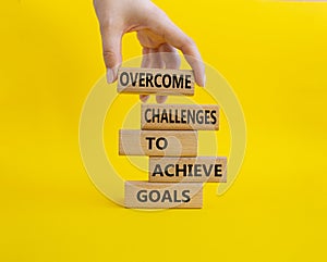 Challenges or goals symbol. Wooden blocks with words Overcome challenges to achieve goals. Beautiful yellow background.