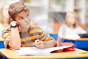 A challenging environment to bring out the best in your child. Young schoolboy thinking really hard about a tough