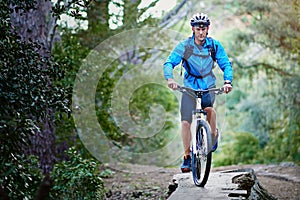 Challenging his limits on the trail. a male cyclist riding along a mountain bike trail.