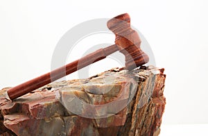 Challenging judicial moments seen in gavel on petrified wood rock
